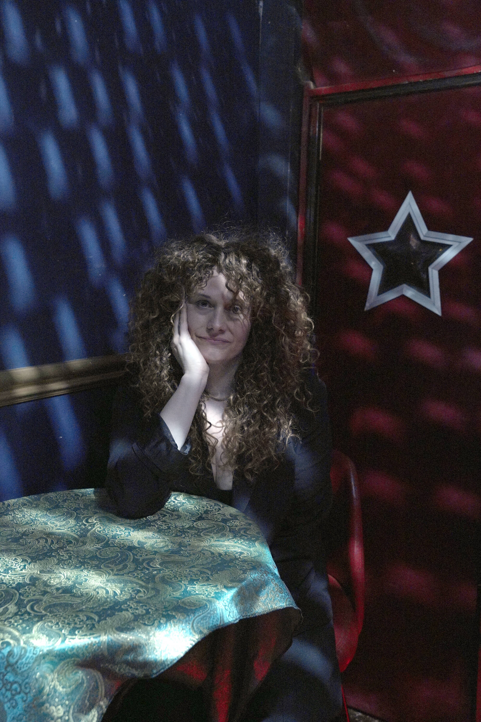 Katie Jean Shinkle wears a contemplative look and rests her head in her palm